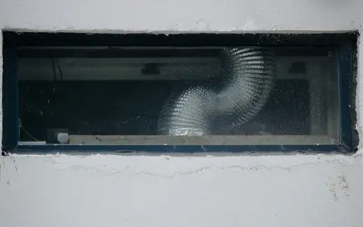 A flexible ventilation duct visible through a small rectangular window.